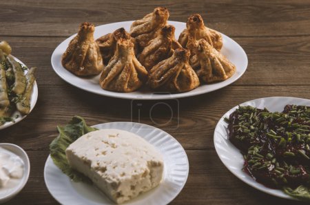 Téléchargez les photos : Plat traditionnel géorgien, khinkali, fromage et dolma sur table en bois. - en image libre de droit