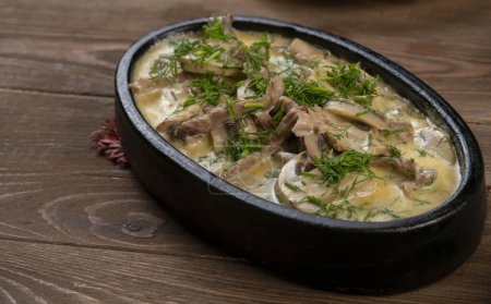 Photo for A dish made of pieces of beef, mushroom in cream sauce on dark wood - Royalty Free Image