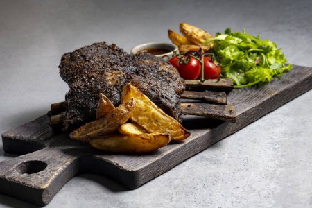 Téléchargez les photos : Grilled pork ribs with french fries and vegetables on a wooden board - en image libre de droit