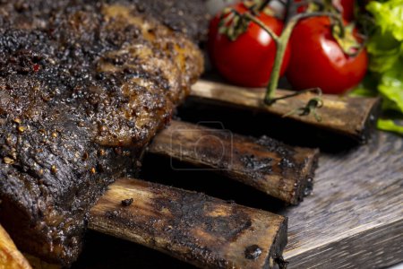 Téléchargez les photos : Grilled pork ribs with french fries and vegetables on a wooden board - en image libre de droit