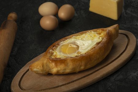 Photo for . Caucasian flatbread adjarian khachapuri with egg on a dark wooden . Adjarian Khachapuri Georgian cheese bread - Royalty Free Image