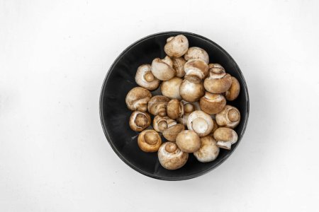 Téléchargez les photos : Vue du dessus des champignons frais dans un bol sur fond blanc - en image libre de droit