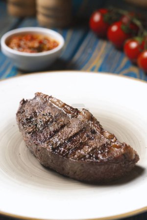 Photo for Grilled steak ,cherry tomatoes salt and pepper on wooden table. - Royalty Free Image