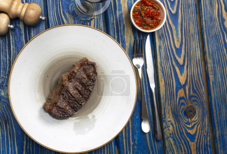Photo for Sirloin steak  and cherry tomatoes on a plate with wine. View from above - Royalty Free Image