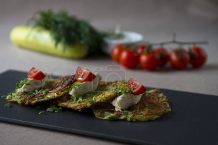 Foto de Panqueques de calabacín con queso feta, tomates cherry y hierbas - Imagen libre de derechos