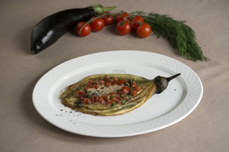Foto de Berenjena al horno con tomate y perejil en un plato blanco - Imagen libre de derechos