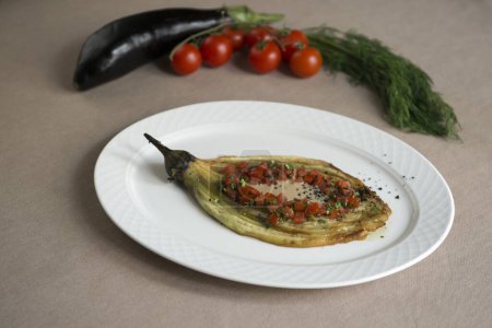 Photo for Eggplant baked with tomato and parsley on a white plate - Royalty Free Image