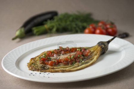 Photo for Eggplant baked with tomato and parsley on a white plate - Royalty Free Image