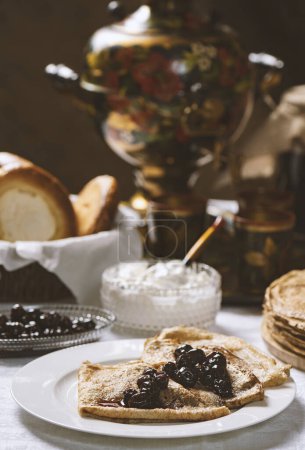 Foto de Panqueques con mermelada de grosella negra en un plato, estilo ucraniano o ruso - Imagen libre de derechos
