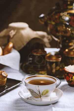 Téléchargez les photos : Tasse de thé chaud avec du sucre sur fond de table floue, mise au point sélective - en image libre de droit