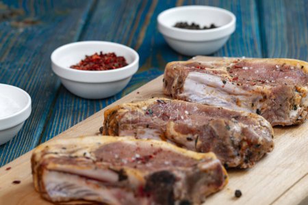 Photo for Raw pork ribs with spices and herbs on cutting board on wooden background - Royalty Free Image