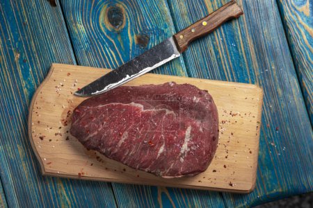 Photo for Raw meat on cutting board with spices on wooden background - Royalty Free Image
