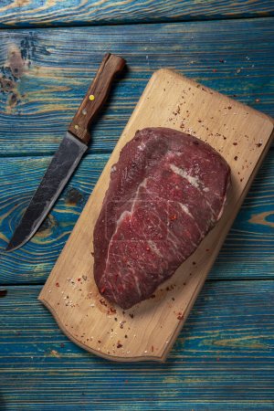 Photo for Raw meat on cutting board with spices on wooden background - Royalty Free Image