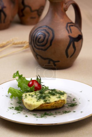 Foto de Patatas al horno con queso y hierbas en un plato y con vino - Imagen libre de derechos