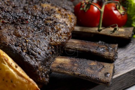 Photo for Grilled pork ribs with french fries and vegetables on a wooden board - Royalty Free Image