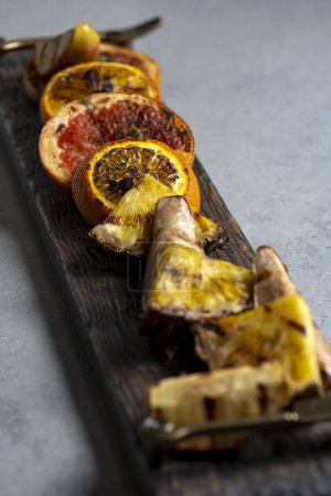 Téléchargez les photos : Slices of dried orange and grapefruit on a wooden board - en image libre de droit