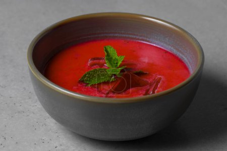 Foto de Cold beetroot soup with mint in a bowl on a gray background - Imagen libre de derechos