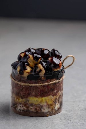 Foto de Pastel de chocolate con profiteroles sobre un fondo gris. Enfoque selectivo. - Imagen libre de derechos
