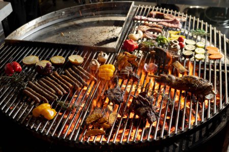 Photo for Roasted meat and vegetables on the grill with flames and vegetables, close up - Royalty Free Image