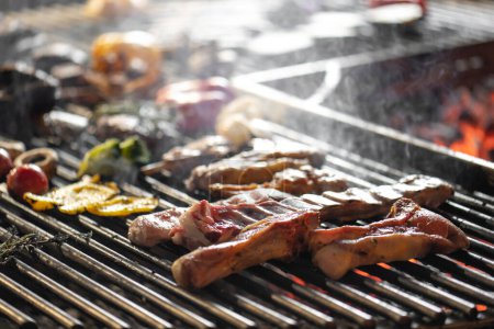 Foto de Carne asada y verduras en la parrilla con llamas y verduras, de cerca - Imagen libre de derechos