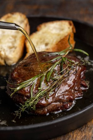 Téléchargez les photos : Steak de bœuf grillé au romarin et baguette grillée - en image libre de droit