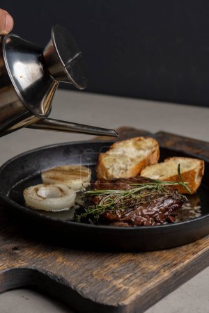 Téléchargez les photos : Steak poêlé avec pain grillé et romarin, arrosé d'huile d'olive - en image libre de droit