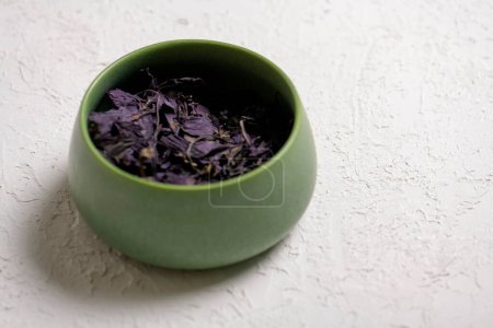 Photo for Dry lavender tea in a green bowl on a white background - Royalty Free Image
