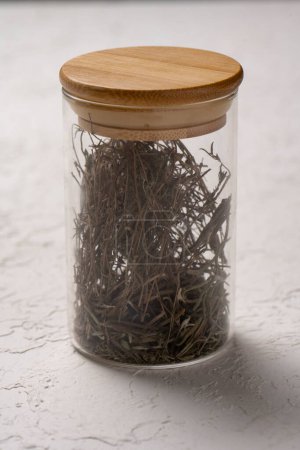 Photo for Dried herbs in a glass jar on a white background. Selective focus. - Royalty Free Image