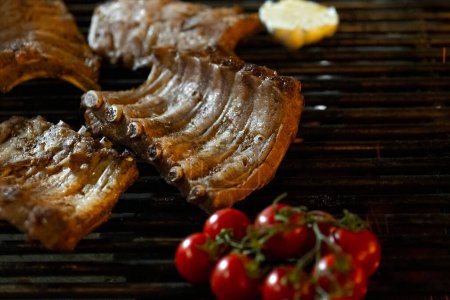 Photo for Grilled pork ribs with cherry tomatoes and cheese on a barbecue grill - Royalty Free Image
