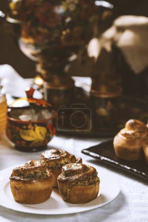 Téléchargez les photos : Petits pains cuits au four avec des graines de pavot sur une nappe blanche. Style ukrainien - en image libre de droit