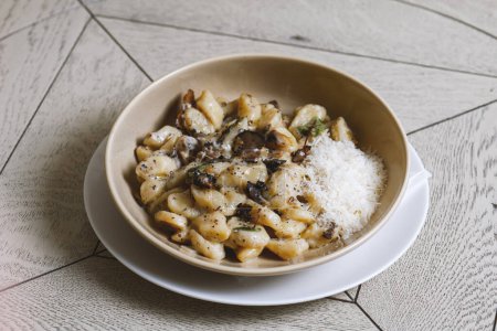 Photo for Pappardelle pasta with mushrooms and parmesan cheese on a plate . Traditional Italian gnocchi pasta with mushroom and parmesan cheese - Royalty Free Image