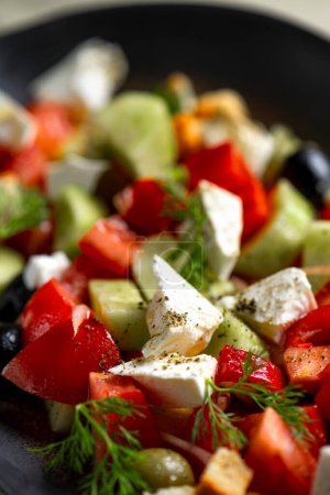 Foto de Ensalada griega con queso feta, tomates, pepinos, cebollas y croutons - Imagen libre de derechos