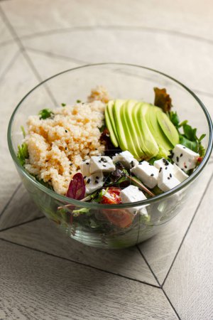 Photo for Salad with quinoa, avocado and feta cheese in a glass bowl - Royalty Free Image
