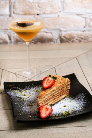 Téléchargez les photos : Couche de gâteau éponge aux fraises sur une plaque noire sur fond en bois - en image libre de droit