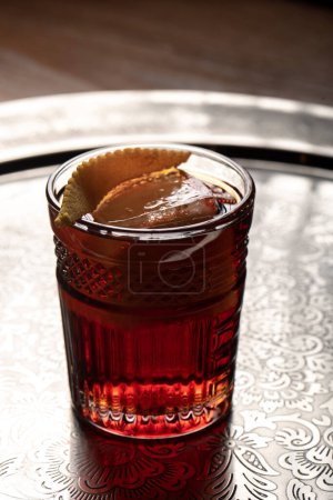 Foto de Cóctel alcohólico en una copa con limón, cubitos de hielo en una bandeja de plata. - Imagen libre de derechos