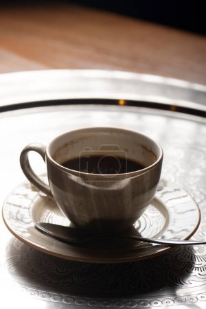 Foto de Una taza de café sin terminar en una bandeja. - Imagen libre de derechos