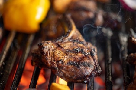 Foto de Carne asada y verduras en la parrilla con llamas y verduras, de cerca - Imagen libre de derechos