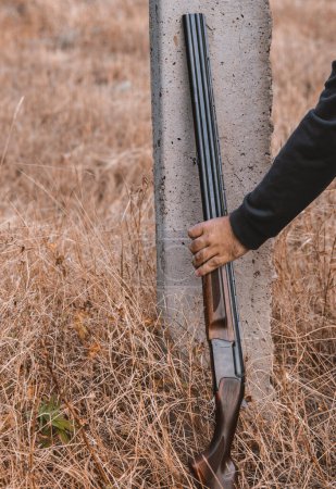 Foto de Escopeta de doble cañón con cartuchos, apoyada en un poste. Concepto de caza - Imagen libre de derechos