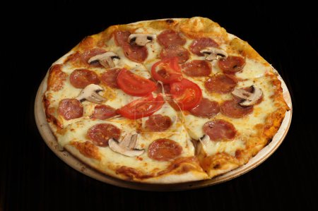 Foto de Pizza with mozzarella cheese, ham and mushrooms on wooden table - Imagen libre de derechos