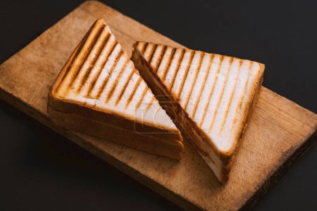 Téléchargez les photos : Club sandwich sur une planche de bois sur un fond sombre - en image libre de droit