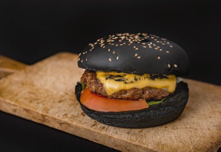 Photo for Tasty black burger in wooden desk. - Royalty Free Image