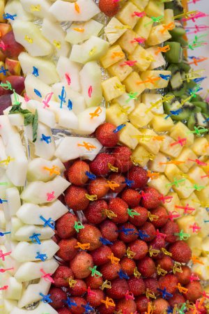 Téléchargez les photos : Bol décoratif de fruits de bienvenue avec fraises fraîches, ananas, pomme, pêche, kiwi - en image libre de droit