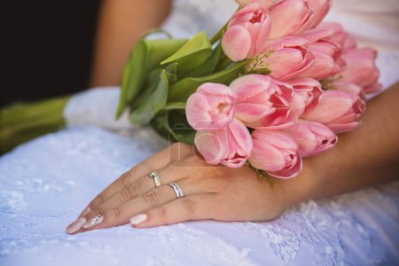 Téléchargez les photos : Une mariée avec un bouquet de tulipes roses sur ses genoux - en image libre de droit