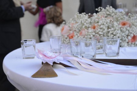 Téléchargez les photos : Wallacha de mariage décoré avec des rubans sur une table posée avec des lunettes - en image libre de droit