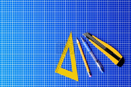 Foto de 3D illustration yellow  cutter,  pencil, pen and ruller on blue background. 3D render and illustration of repair and installation tool - Imagen libre de derechos