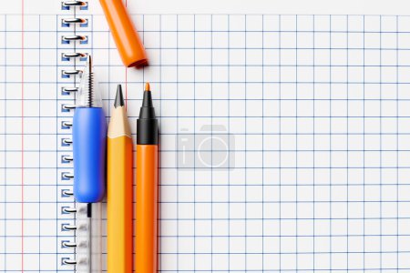 Foto de Blue pencils, colored ink pens and a regular pencil, a school notebook in a cage. 3D illustration. Stationery - Imagen libre de derechos