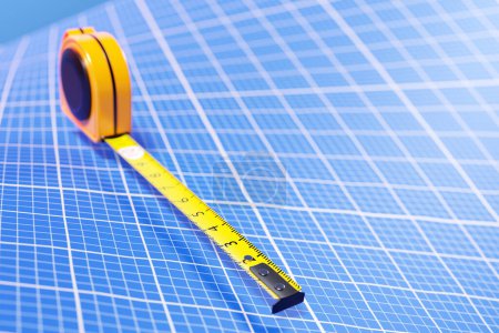Téléchargez les photos : Illustration 3D d'un mètre ruban jaune sur fond de papier graphique bleu. Outil de mesure portatif pour la construction, la rénovation ou la menuiserie. - en image libre de droit
