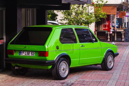 Foto de Side, Turkey -January 21, 2023:   green Volkswagen Golf , back  view,  is parked  on the street on a warm summer day - Imagen libre de derechos