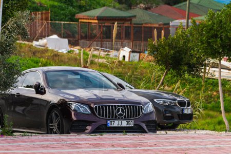 Foto de Side, Turkey -21 de enero de 2023: Mercedes-Benz E-class negro está estacionado en la calle en un día cálido con el telón de fondo de un jardín - Imagen libre de derechos