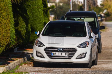 Photo for Side, Turkey -January 21, 2023:  white Hyundai I30  is parked  on the street on a warm day against the backdrop of a buildung,   trees - Royalty Free Image